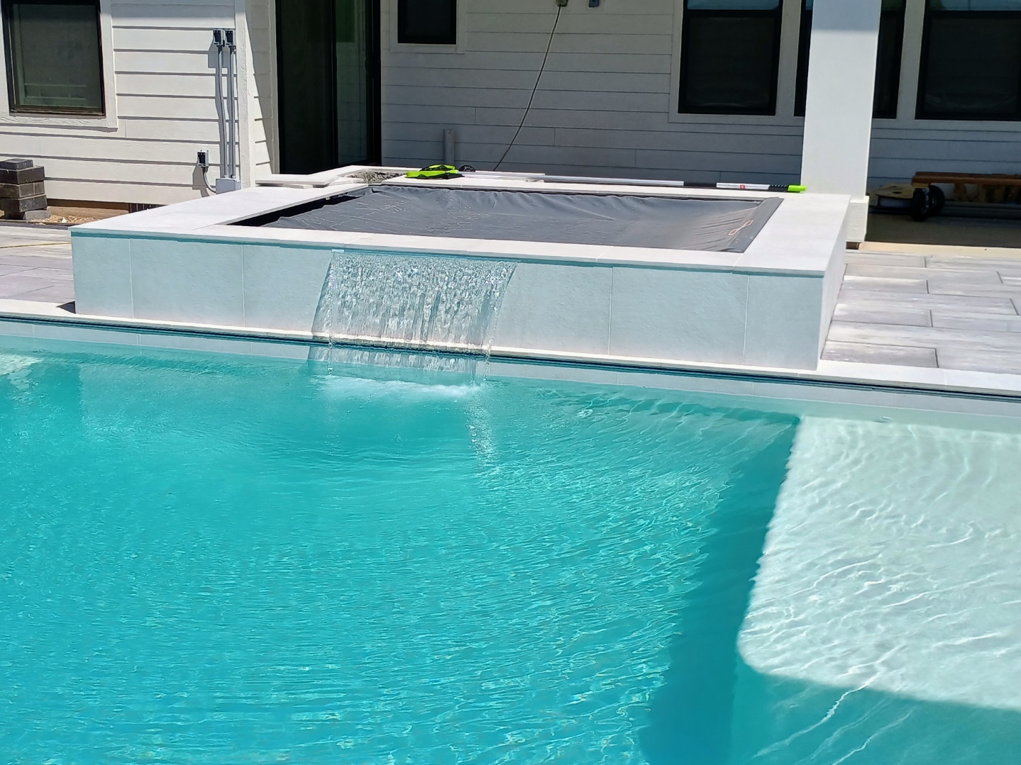 Modern pool with spa and waterfall feature by Universal Pools Meridian Idaho