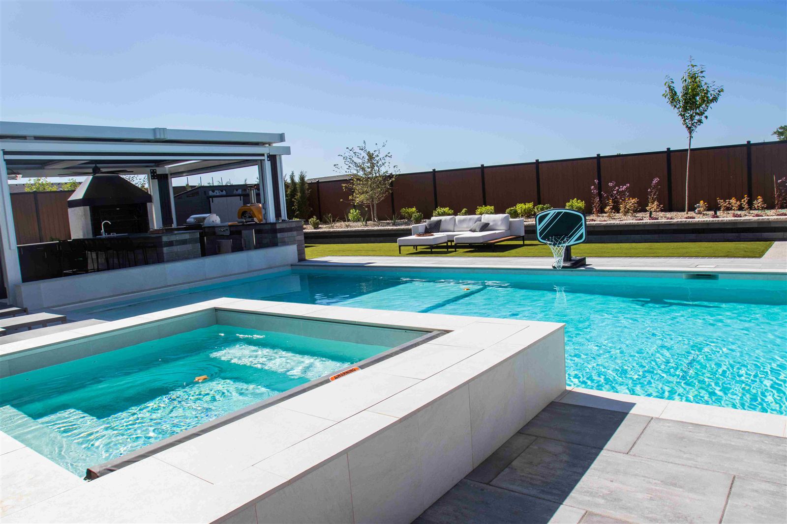 Custom gunite pool and spa with outdoor kitchen and poolside basketball hoop built by Universal Pools Idaho