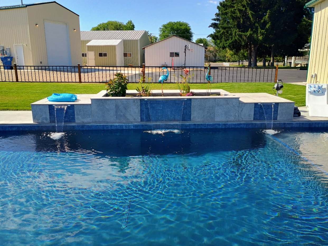 Pool with water features and raised planter built by Universal Pools